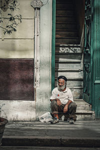 Man sitting on staircase of building