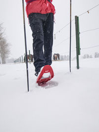 Snowshoe hiking in land. active outdoor man hikes in farm range in snowfalling