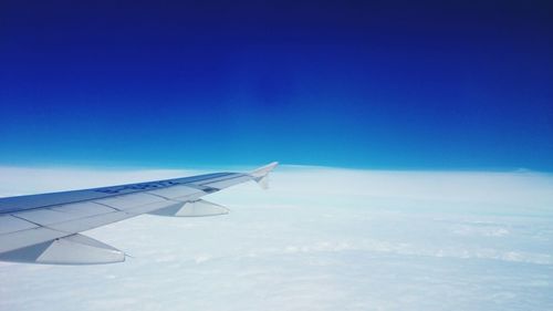 Close-up of airplane wing against blue sky