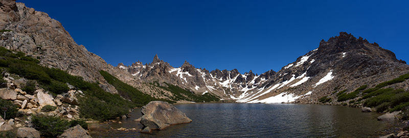 Panoramic view of rocks and mountains against clear blue sky