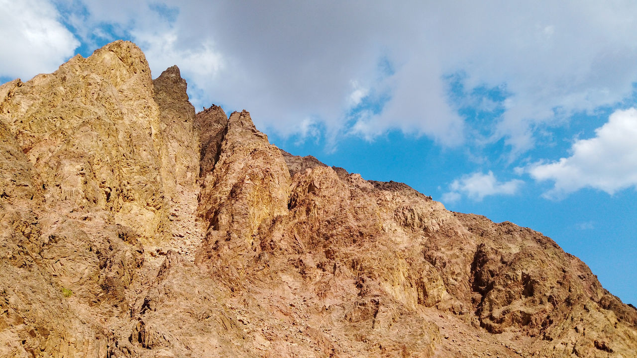 LOW ANGLE VIEW OF ROCK FORMATION ON MOUNTAIN AGAINST SKY