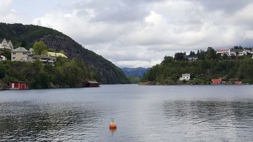 Scenic view of sea by buildings against sky
