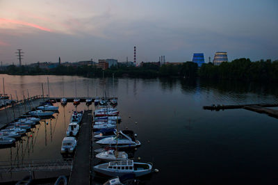 Boats moored at harbor during sunset