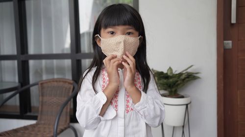 Portrait of girl holding mask