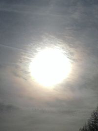 Low angle view of sun shining through clouds