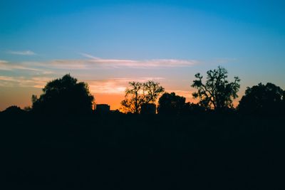 Silhouette trees on landscape against sky