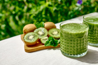 Green smoothie with kiwi fruit in the glasses. healthy organic drink. nutrition and alkaline diet.