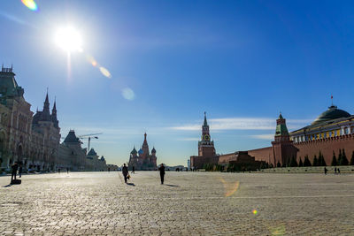 Tourists walking on red square near gum, st basils cathedral and dome of senate