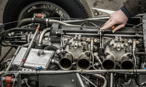 Cropped hand of man repairing engine