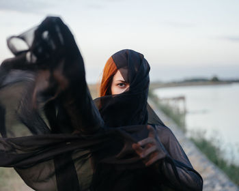 Portrait of woman against black sky