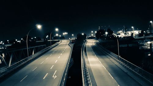 Light trails on road in city against clear sky at night