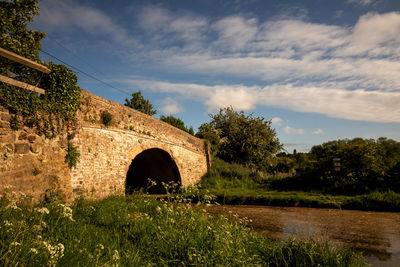 Arch bridge over river against sky