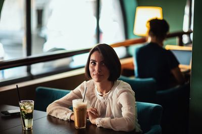 Woman sitting on table at restaurant