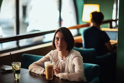 Thoughtful woman having coffee in cafe