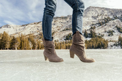 Low section of woman standing on snow