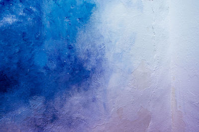 Abstract blue and white painted wall texture background outdoors.