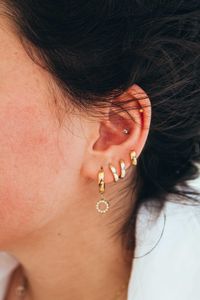 Close up of the woman with multiple piercings on the ear