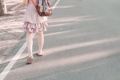 Low section of woman walking on road