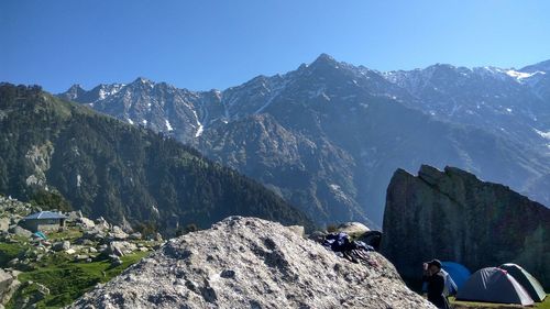 Side view of man standing at campsite against mountain