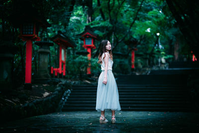 Full length of woman standing by tree