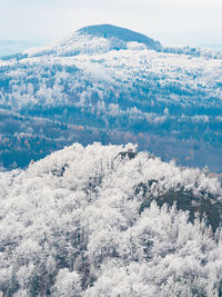 Dark blue forest hills covered with hoarfrost. early winter freeze weather. hoarfrost on treetops