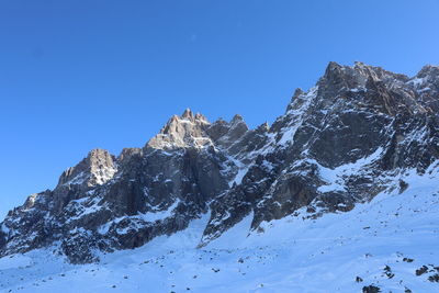 Scenic view of snowcapped mountains against clear blue sky