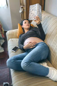 Young woman sitting on sofa at home