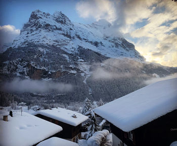 Snow capped chalets in front of the mighty eiger north face. grindelwald, switzerland 
