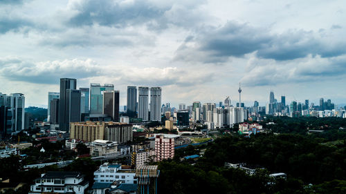 View of cityscape against cloudy sky