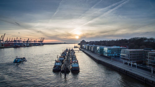 Boats moored on sea against sky during sunset