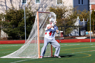 Full length of boy playing on field against trees