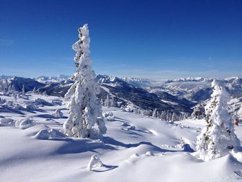 Scenic view of snowcapped mountains against clear blue sky