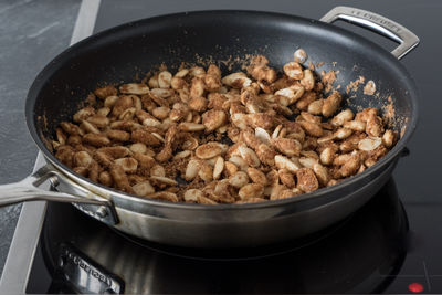 Close-up of candied almonds in pan on induction cooktop