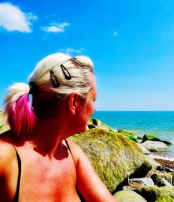 Woman looking at sea against sky