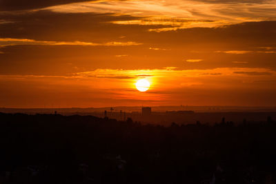 Scenic view of silhouette landscape against orange sky