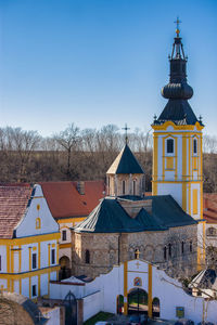 Houses and buildings against clear blue sky