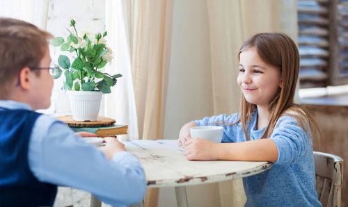 Portrait of smiling girl sitting on table