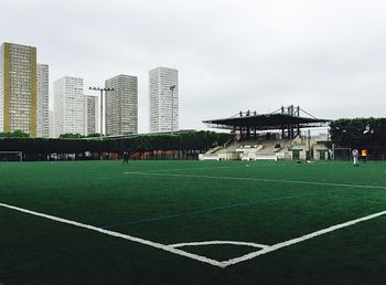 Football ground against tall buildings