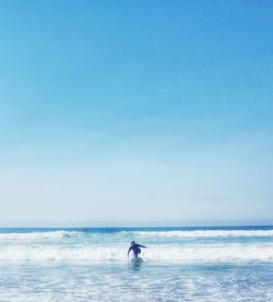 Man standing on beach against clear sky