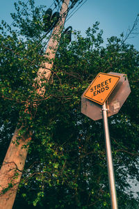 Low angle view of road sign against trees