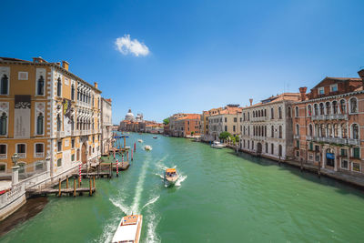 Boats in canal amidst buildings in city