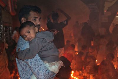 Portrait of cute girl standing by fire