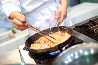 Midsection of chef preparing food in kitchen