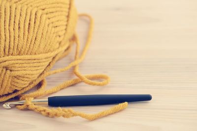 Close-up of knitting needle and wool on wooden table