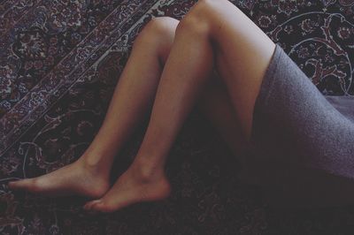 Low section of woman resting on carpet