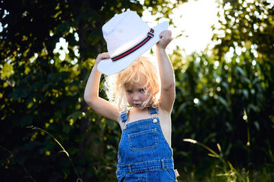 Girl wearing mask against trees