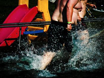 Shirtless men splashing water at park