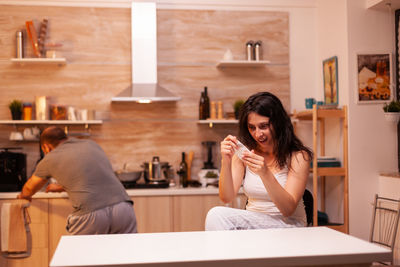 Young woman using mobile phone while sitting at restaurant