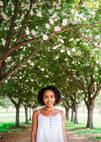 Young woman standing against trees