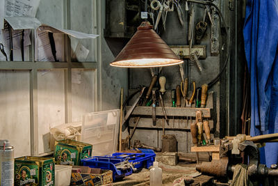 Illuminated pendant light over hand tools in workshop